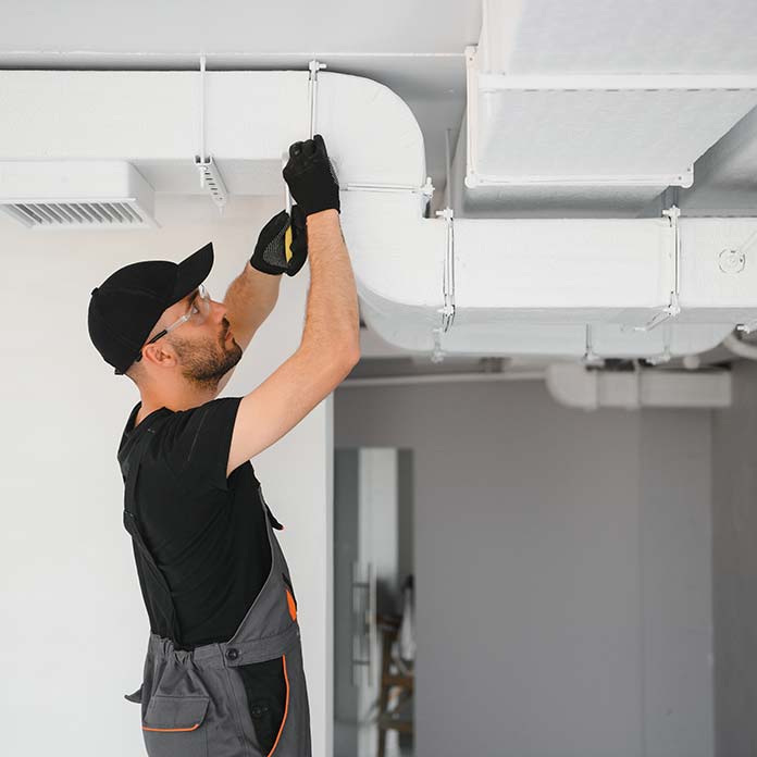 Installateur arbeitet an einer Lüftungsanlage
